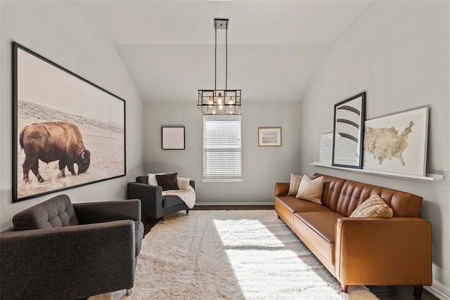 living room featuring a notable chandelier, vaulted ceiling, and baseboards