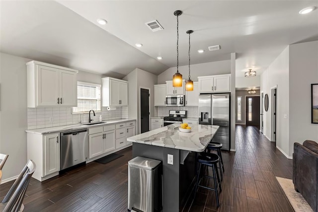 kitchen with lofted ceiling, visible vents, appliances with stainless steel finishes, and a sink