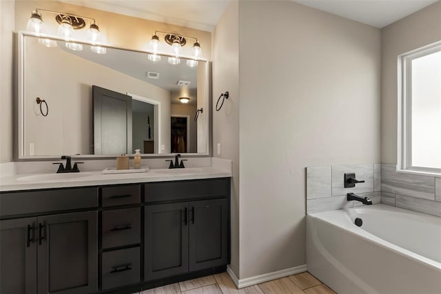 full bath featuring double vanity, a garden tub, baseboards, and a sink