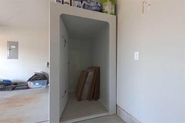 hallway with concrete floors and electric panel