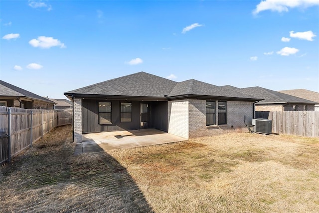 back of property featuring a patio, a fenced backyard, central air condition unit, brick siding, and roof with shingles