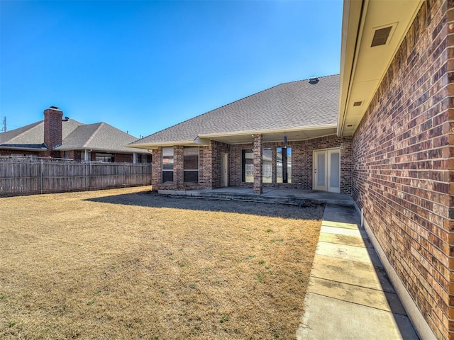 view of yard with fence and a patio