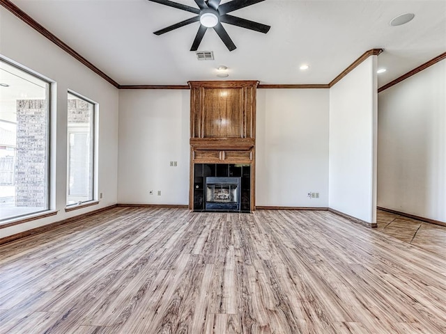 unfurnished living room with baseboards, visible vents, ornamental molding, light wood-type flooring, and a fireplace