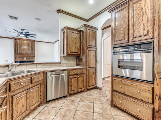 kitchen featuring appliances with stainless steel finishes, visible vents, a sink, and ornamental molding