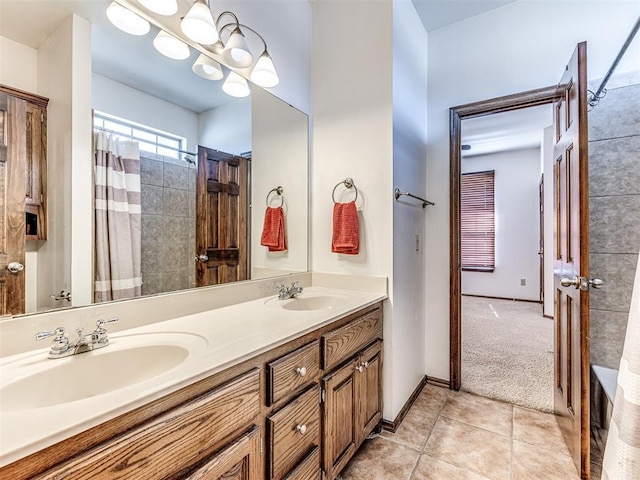 full bath featuring tile patterned flooring, a sink, baseboards, and double vanity