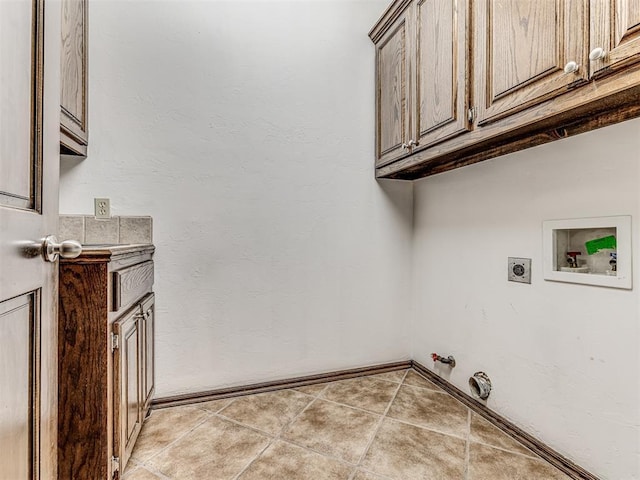 washroom with light tile patterned floors, hookup for a gas dryer, washer hookup, cabinet space, and electric dryer hookup