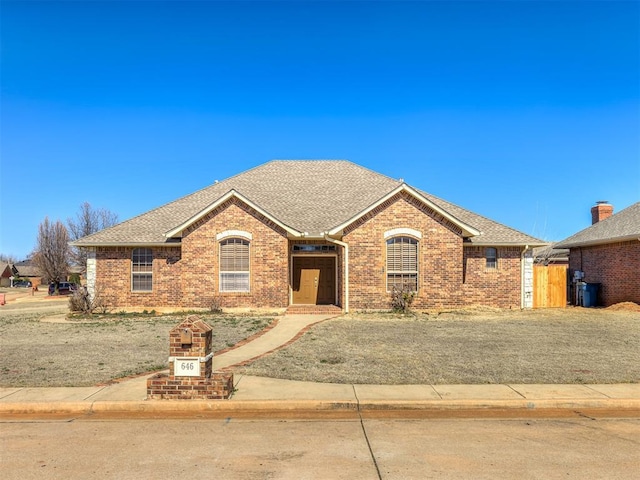 ranch-style house with brick siding and roof with shingles