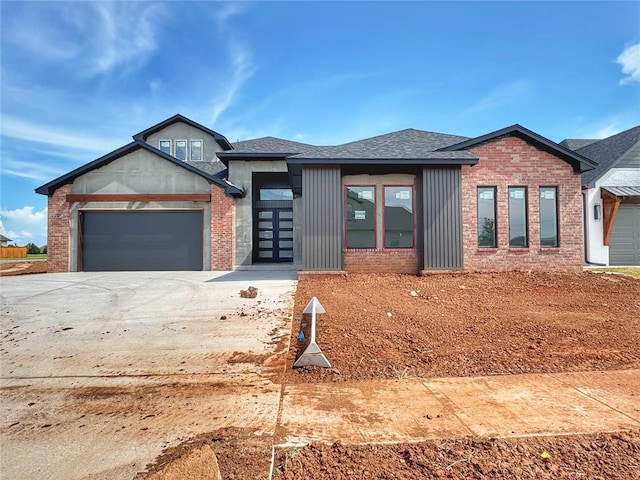 15428 Hatterly Ln, Edmond, OK 73013 - view of front facade with an attached garage, driveway, brick siding, and a shingled roof