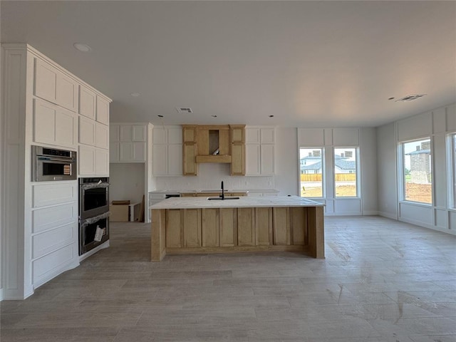15428 Hatterly Ln, Edmond, OK 73013 - kitchen featuring wall chimney exhaust hood, a large island, backsplash, double oven, and white cabinets