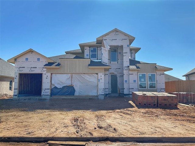 unfinished property with an attached garage and fence