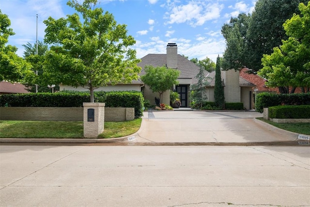 view of front of house featuring driveway and a chimney