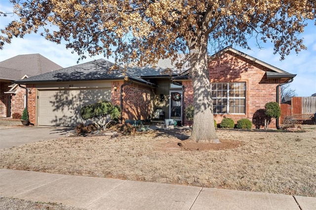 ranch-style home with a garage, concrete driveway, brick siding, and fence