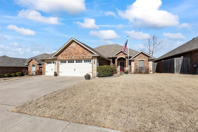 single story home featuring a garage, driveway, fence, and brick siding