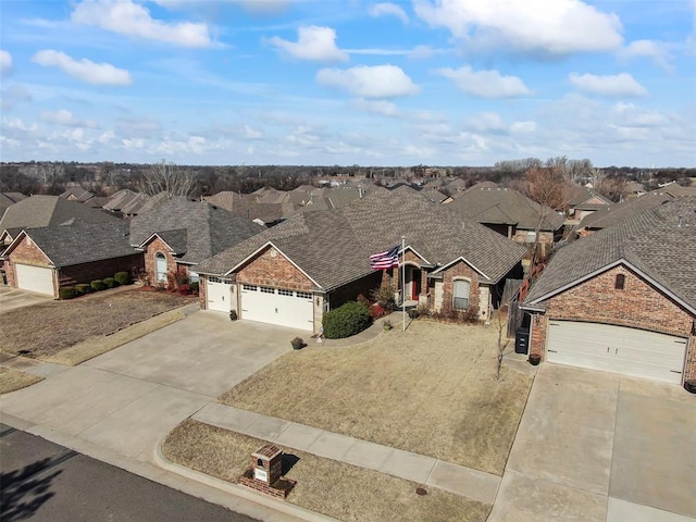 view of front of property featuring concrete driveway, an attached garage, and a residential view