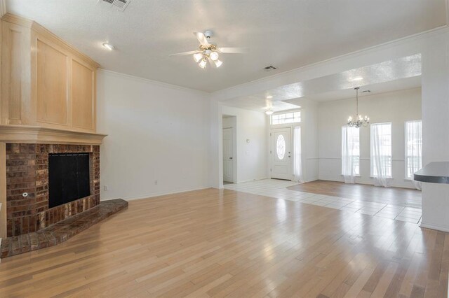 3005 Weymouth Way, Norman, OK 73071 - unfurnished living room featuring ceiling fan, a chandelier, light wood-type flooring, a brick fireplace, and crown molding