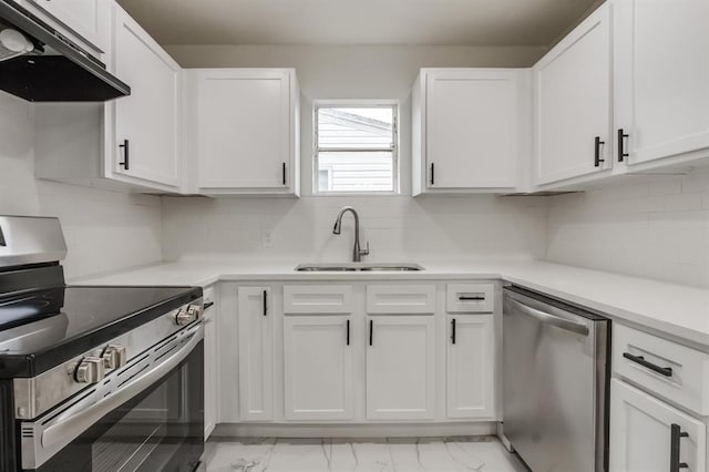 kitchen with marble finish floor, appliances with stainless steel finishes, white cabinetry, a sink, and under cabinet range hood