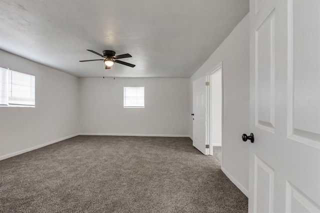 carpeted spare room featuring a ceiling fan and baseboards