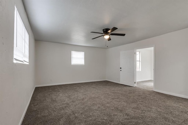 carpeted empty room featuring ceiling fan and baseboards