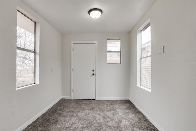 carpeted entryway featuring baseboards