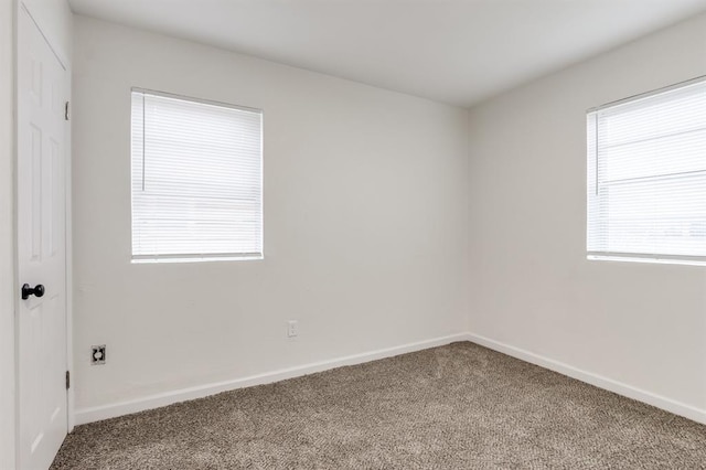 empty room featuring carpet flooring and baseboards