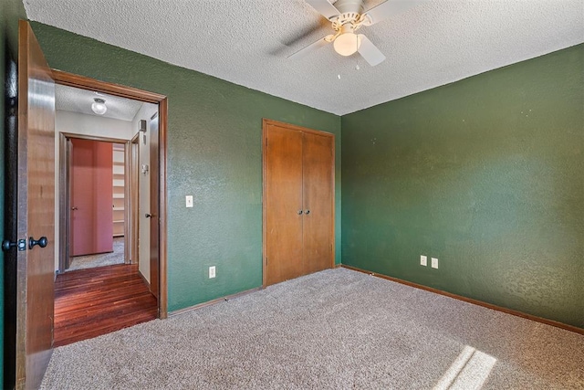 unfurnished bedroom with a textured ceiling, a textured wall, a closet, and carpet