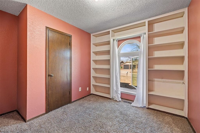 unfurnished bedroom with carpet flooring and a textured ceiling