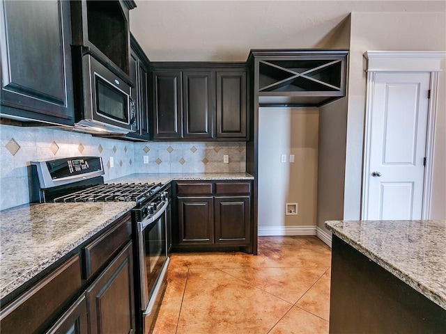 kitchen with stainless steel appliances, light stone countertops, light tile patterned floors, and tasteful backsplash