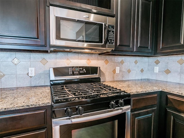 kitchen with light stone countertops, tasteful backsplash, stainless steel appliances, and dark brown cabinets