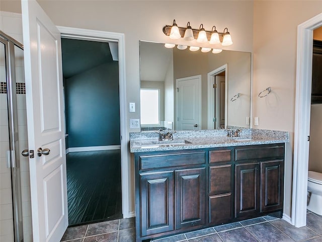 full bath with double vanity, tile patterned flooring, a sink, and toilet