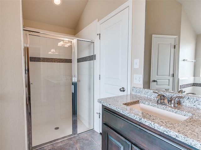 full bathroom with lofted ceiling, a stall shower, tile patterned flooring, and vanity