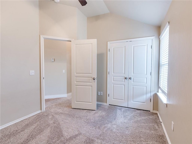 unfurnished bedroom featuring vaulted ceiling, carpet floors, and multiple windows