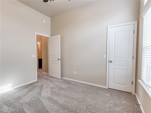 carpeted spare room featuring visible vents and baseboards