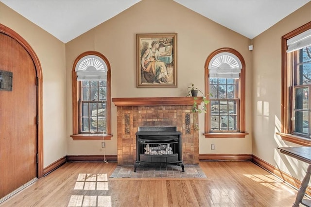 unfurnished living room with lofted ceiling, a healthy amount of sunlight, and wood finished floors