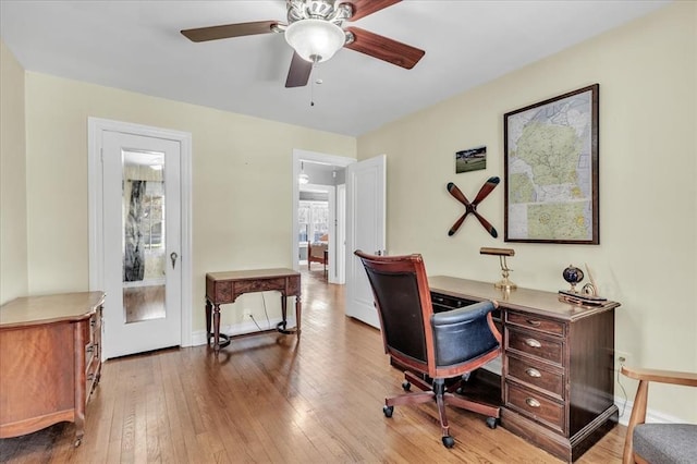 office space with a ceiling fan, wood-type flooring, and baseboards