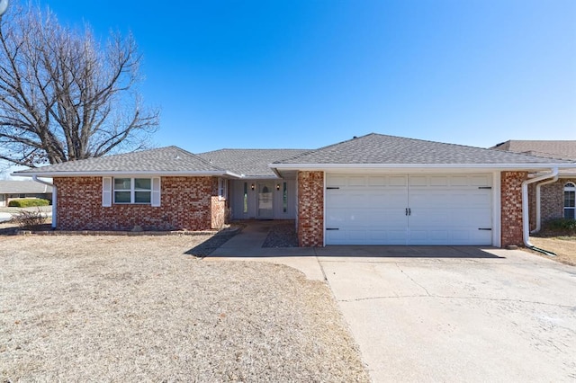 ranch-style home featuring a garage, brick siding, driveway, and roof with shingles