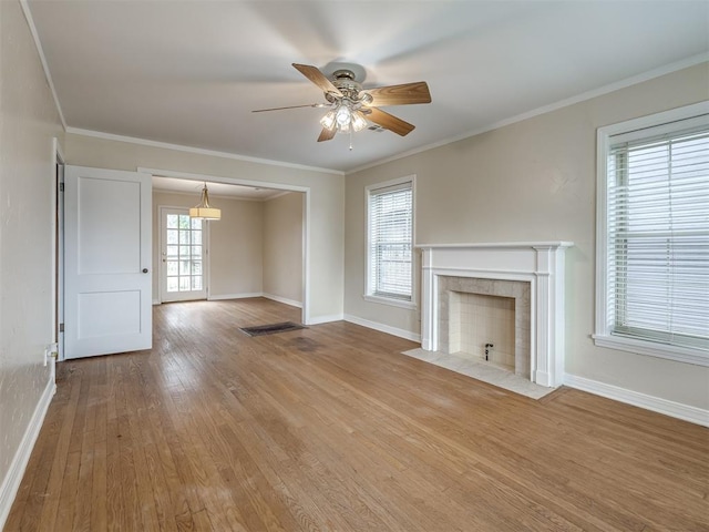 unfurnished living room with crown molding, wood finished floors, and baseboards