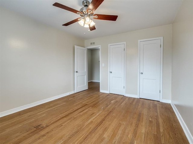 unfurnished bedroom featuring visible vents, ceiling fan, light wood-style floors, and baseboards