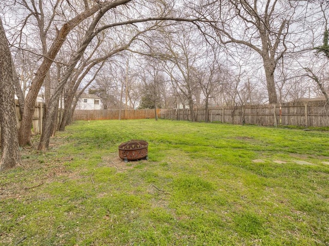 view of yard with a fire pit and a fenced backyard