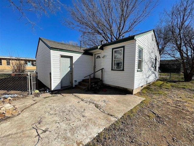 rear view of property featuring fence and driveway