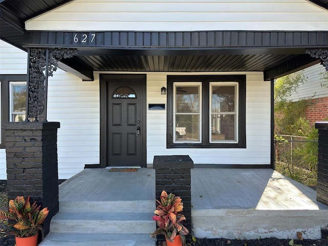 view of exterior entry featuring covered porch