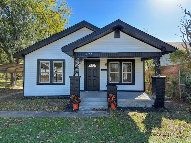 bungalow-style home with a carport and a porch