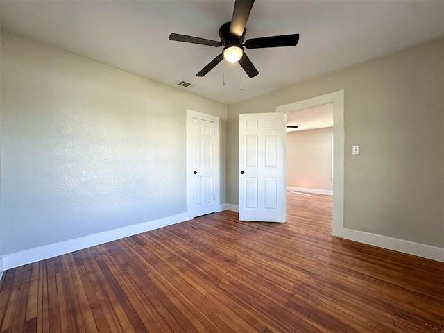 unfurnished bedroom featuring hardwood / wood-style floors, visible vents, and baseboards