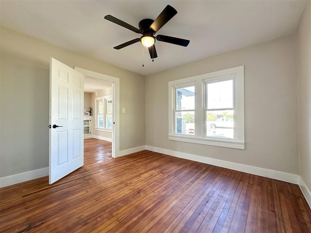 empty room with a ceiling fan, baseboards, and hardwood / wood-style floors