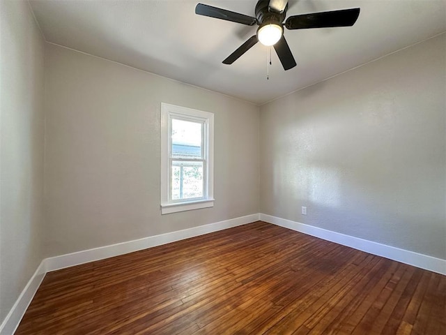 unfurnished room with dark wood-style floors, ceiling fan, and baseboards