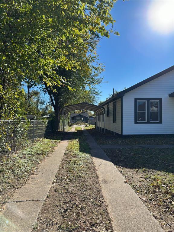 view of side of home featuring fence and a detached carport