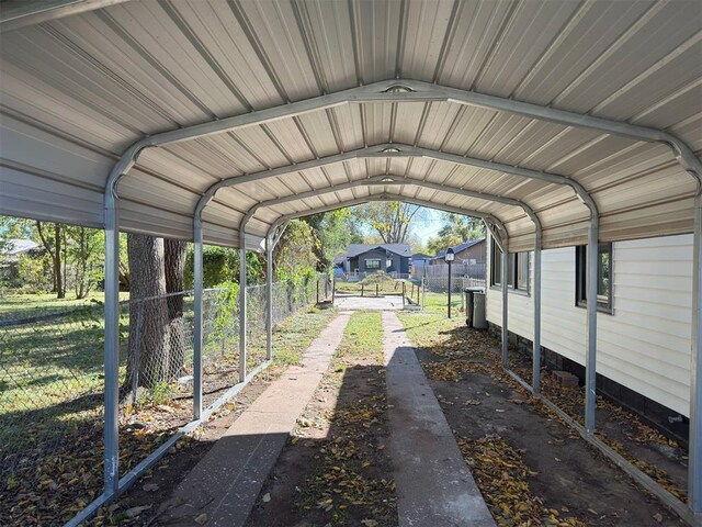 view of parking with a carport and fence