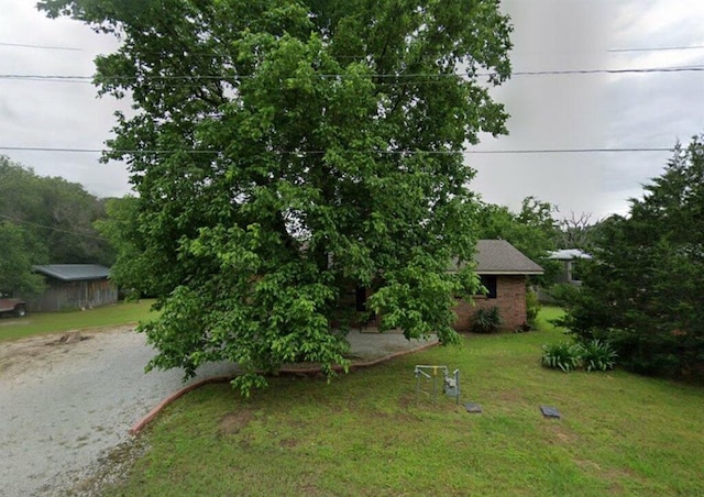 view of front facade with brick siding and a front lawn