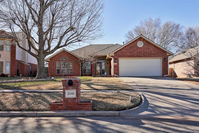 ranch-style home with driveway, brick siding, and an attached garage