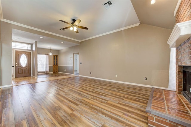 unfurnished living room featuring crown molding, visible vents, a fireplace, and light wood-style flooring