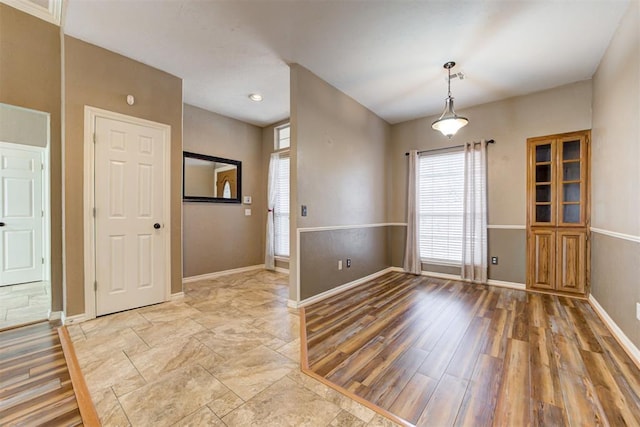 interior space with baseboards and light wood finished floors